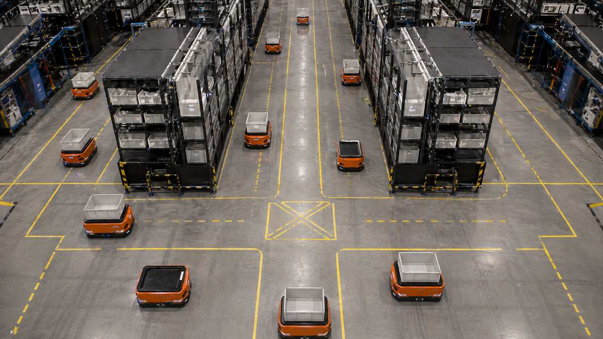 Autonomous mobile robots carrying totes in goods-to-person warehouse system