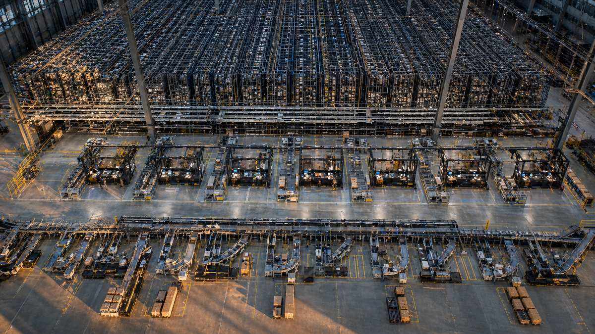 Large-scale goods-to-person ASRS warehouse with multiple picking stations and robot fleet