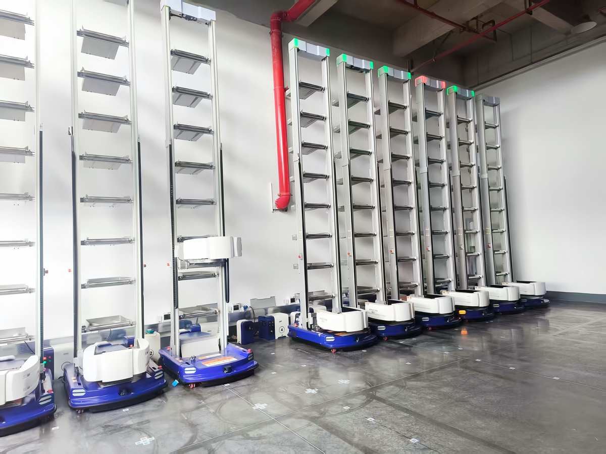 Robotic goods-to-person ASRS system with bin-carrying robots in warehouse